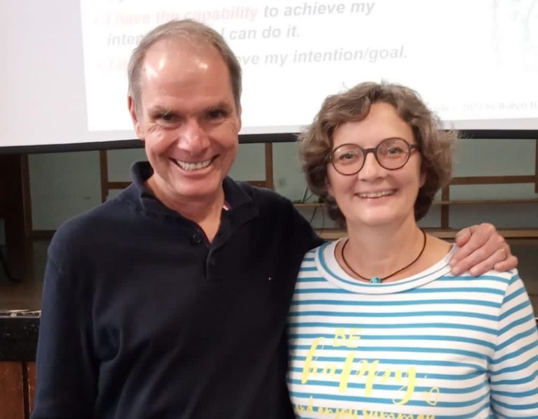 Gruppe von Menschen beim Aufstellen eines Zeltes im Freien. Teamarbeit wird gezeigt.